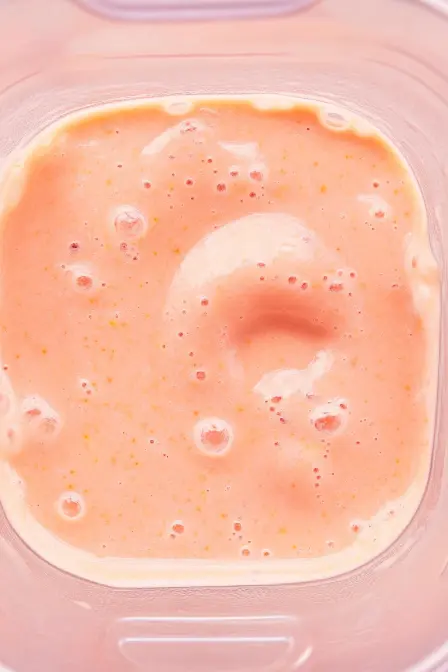 creamy strawberry mango banana smoothie inside blender