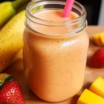 strawberry mango banana smoothie in mason jar with fresh fruits